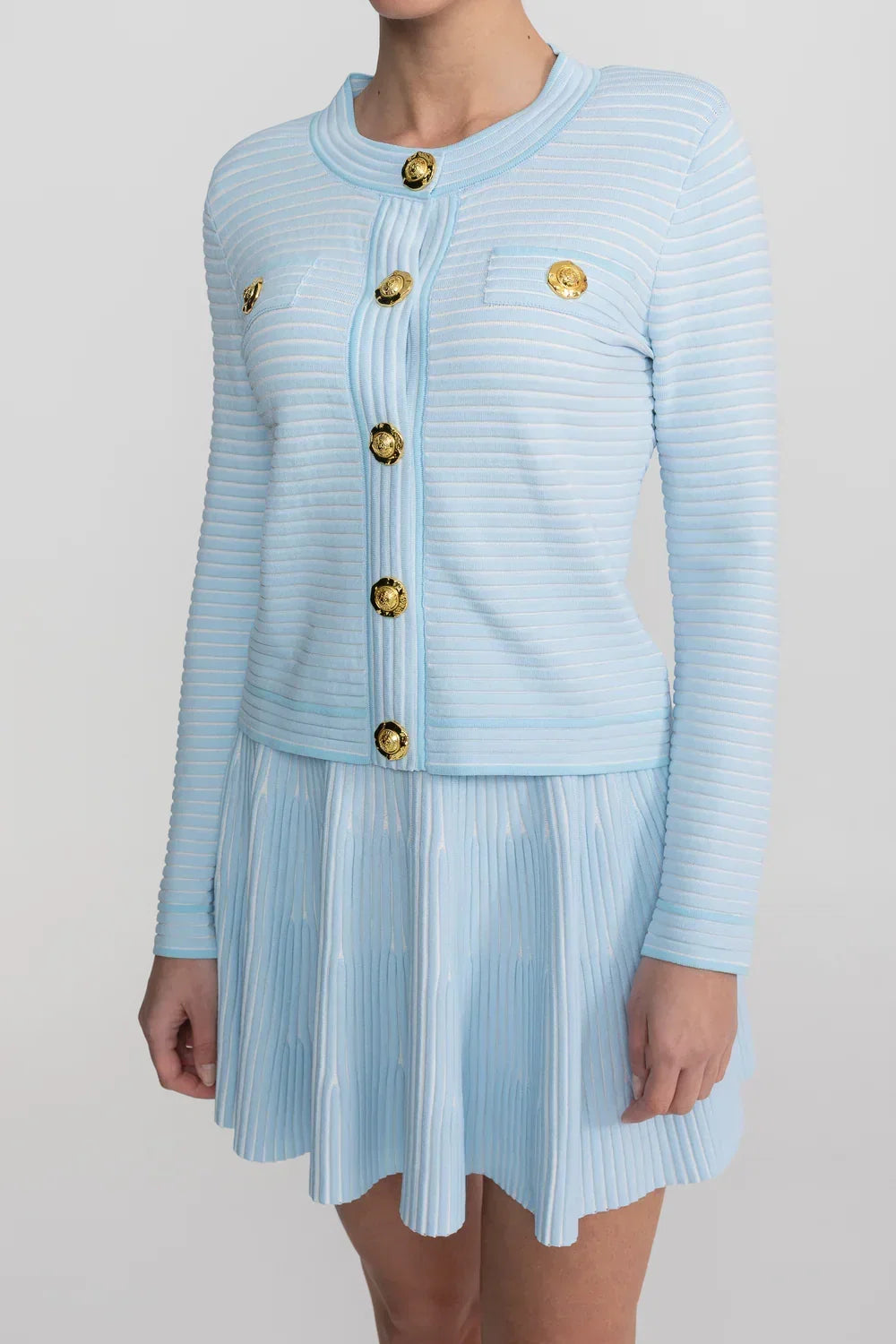 Conjunto em Tricô Estruturado -  Cardigan com Botões Dourados e Saia Plissada
